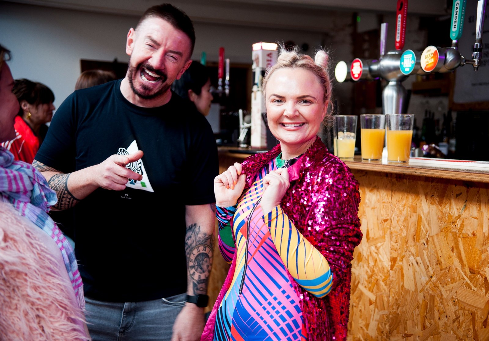 Two guests smiling together, one in a pink sequinned jacket